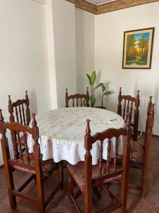stół jadalny i krzesła z białym stołem oraz stołem i krzesłami w obiekcie Departamento completo a dos cuadras de la plaza principal , sin ascensor por el momento y con cochera w mieście San Ramón de la Nueva Orán