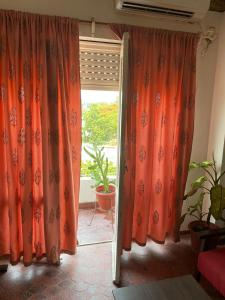 an open door with orange curtains in a room at Departamento completo a dos cuadras de la plaza principal , sin ascensor por el momento y con cochera in San Ramón de la Nueva Orán