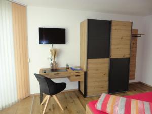 um quarto com uma secretária, uma cama e uma cadeira em Apart Kofler em Längenfeld