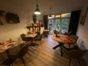 ein Wohnzimmer mit Tischen und Stühlen sowie ein Esszimmer in der Unterkunft Pension Auberge de Dael in Valkenburg