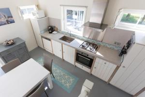 einen Blick über eine Küche mit weißen Geräten in der Unterkunft Hello Zeeland - Vakantiehuis Brouwerijweg 43-4 in Domburg