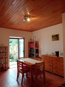 a dining room with a table and wooden ceiling at Pêssego - AL in Arouca