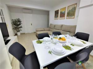 a white table and chairs in a living room at Gades Natura Apartment a 450 mts Victoria beach in Cádiz