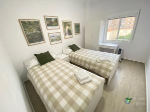 a room with two beds and a window at Gades Natura Apartment a 450 mts Victoria beach in Cádiz
