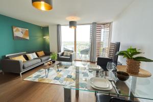 a living room with a couch and a glass table at ShortstayMK Vizion apartments, with free superfast wi-fi, parking, Sky sports and movies in Milton Keynes