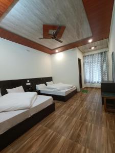 究希瑪斯的住宿－Jai Bajrangi Guest House，一间卧室配有两张床和吊扇