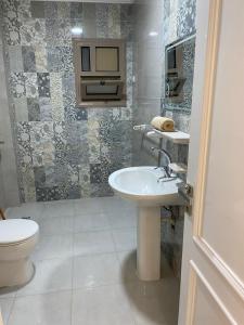 a bathroom with a sink and a toilet at شقة فندقية مميزة بالمنصورة in Ṭalkha