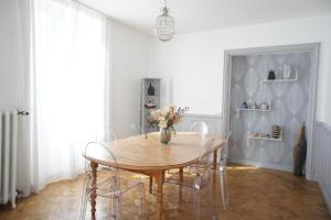 MAS TERRE Chambres d'Hôtes في Lezoux: غرفة طعام مع طاولة وكراسي خشبية