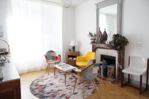 een woonkamer met een open haard met stoelen en een spiegel bij MAS TERRE Chambres d'Hôtes in Lezoux