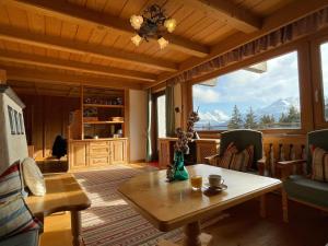 a living room with a table and a large window at Buena Vista Mountain Lodge in Mittersill