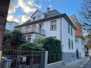 une maison blanche avec une clôture devant elle dans l'établissement Studio côté Parc des Contades, à Strasbourg