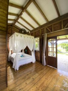 a bedroom with a bed with a canopy at Bungalow à flanc de montagne in Le Morne Rouge