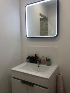 y baño con lavabo blanco y espejo. en Les Micocouliers - Spacieuse maison,4chambres ,avec Jardin- Parking -Wifi en Béziers