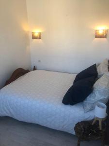 1 dormitorio con 1 cama blanca y 2 luces en la pared en Les Micocouliers - Spacieuse maison,4chambres ,avec Jardin- Parking -Wifi en Béziers