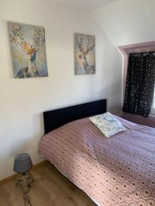 sypialnia z łóżkiem i 2 zdjęciami na ścianie w obiekcie 1)Maison chaleureuse à 2 pas de la Seine w mieście Duclair