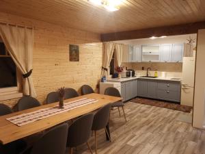 uma cozinha e sala de jantar com mesa e cadeiras em Cabana Katica 2 vendégház em Borzont