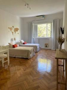 1 dormitorio con 2 camas y suelo de madera en Departamento en pleno Recoleta en Buenos Aires