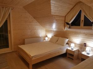 una camera da letto con letto in una camera in legno di Cabana Katica 2 vendégház a Borzont