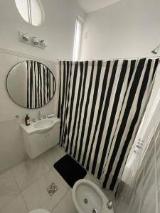 baño con cortina de ducha de rayas en blanco y negro en Departamento en pleno Recoleta en Buenos Aires