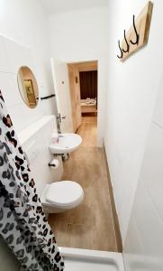 ein Badezimmer mit einem weißen WC und einem Waschbecken in der Unterkunft ELENA flat Sonnenblumen Duisburg Zentrum in Duisburg