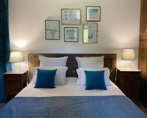 a bedroom with a bed with blue and white pillows at La Perle de la Lauzière, chambres d hôtes in Argentine