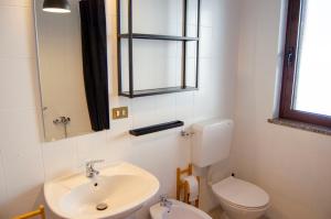 a bathroom with a sink and a toilet and a mirror at BBkey La casetta Arta Terme in Arta Terme +18 photos