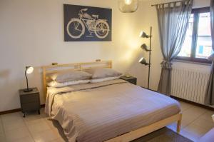 ein Schlafzimmer mit einem Bett mit einem Fahrrad an der Wand in der Unterkunft BBkey La casetta Arta Terme in Arta Terme