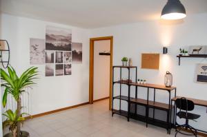 a room with a desk and a table and chairs at BBkey La casetta Arta Terme in Arta Terme