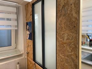 a sliding glass door in a bathroom with a window at Studio côté Parc des Contades in Strasbourg