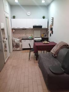 cocina y sala de estar con sofá y mesa en La Casa di Francy, en Nápoles