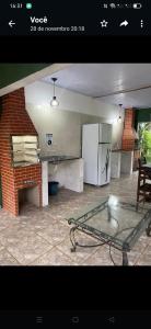a kitchen with a glass table and a refrigerator at Rancho Vista Verde in Ubatuba