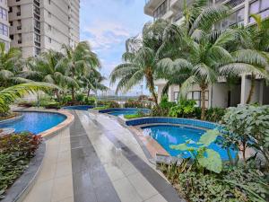 a row of swimming pools in a resort with palm trees at Royal Strand, Country Garden Danga Bay Homestay by WELCOME HOME in Johor Bahru