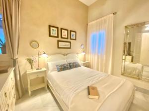 a bedroom with a white bed with a book on it at innCádizPalacio Apolo in Cádiz