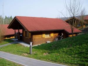 Cabaña pequeña con techo rojo en una colina en Naturerlebnisdorf Stamsried 2, en Stamsried