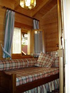 a couch in a log cabin with a window at Naturerlebnisdorf Stamsried 2 in Stamsried