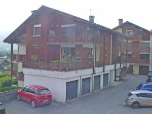 czerwony samochód zaparkowany przed budynkiem w obiekcie T2 cosy, proche centre Samoëns, animaux admis, parking - FR-1-629-67 w mieście Samoëns