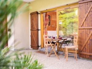 stół i krzesła na patio z drzwiami w obiekcie Appartement cosy pour 3 pers, piscine, proche commerces, à Arêches-Beaufort - FR-1-342-131 w mieście Beaufort