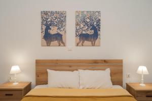 sypialnia z dwoma obrazami jeleni i drzew w obiekcie Apt in the historic center, next to Acropolis w Atenach