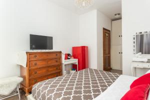sypialnia z łóżkiem i telewizorem na komodzie w obiekcie Cagliari Centro Città Rooms w Cagliari