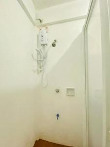 a bathroom with a white wall with a shower at La Casa Blanca Binoclutan in Botolan +43 photos