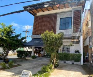 a building with a sign in front of it at No.210 Maikhao Bedroom Studio in Ban Dan