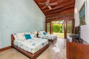 una camera da letto con due letti e una TV a schermo piatto di Casa de Campo Luxury Villas - Private Paradise at La Romana a La Romana