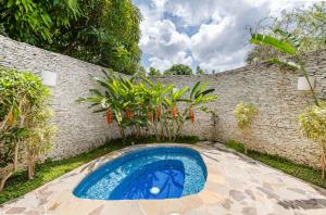 una piscina en un patio trasero con una pared de ladrillo en Casa de Campo Luxury Villas - Private Paradise at La Romana en La Romana