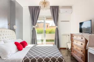 sypialnia z łóżkiem z czerwonymi poduszkami i oknem w obiekcie Cagliari Centro Città Rooms w Cagliari