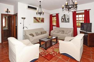 a living room with white furniture and a tv at Villa Don Pedro in Tijarafe