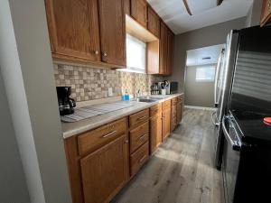 una cocina con armarios de madera y electrodomésticos de acero inoxidable en Restful single bedroom getaway en Billings