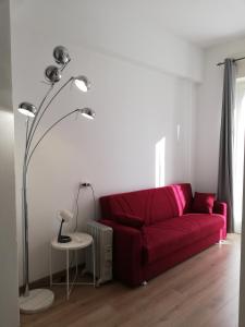 加拉瑞特的住宿－Palazzo Pasta Malpensa，客厅里红色的沙发,配有灯