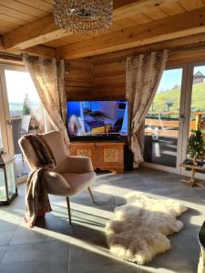 a living room with a tv and a chair and a rug at Chata w Grapie in Koniaków