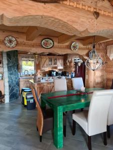 a dining room with a green table and chairs at Chata w Grapie in Koniaków