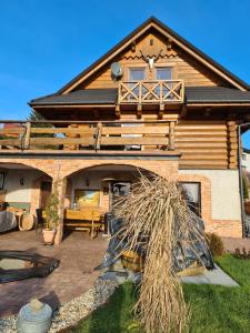 a log house with a patio and a roof at Chata w Grapie in Koniaków